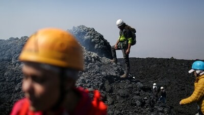 Tourists walk on a slope on Mount Etna as the volcano emits smoke, near Catania, Sicily, Italy, August 21, 2025. REUTERS/Antonio Denti (REUTERS)