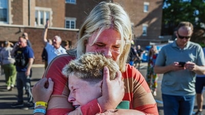 A mourner is seen embracing a child, crying as they grieve together following the mass shooting in Minneapolis. (AP Photo/Bruce Kluckhohn) (AP) A mourner is seen embracing a child, crying as they grieve together following the mass shooting in Minneapolis. (AP Photo/Bruce Kluckhohn) (AP)