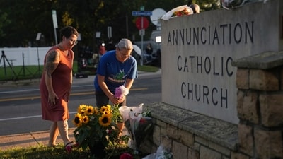 Susan Saly and Meagan Pierlouissi laid flowers at a growing memorial outside Annunciation Catholic Church on Thursday, paying tribute to the victims of the tragic school shooting. (AP Photo/Abbie Parr) (AP) Susan Saly and Meagan Pierlouissi laid flowers at a growing memorial outside Annunciation Catholic Church on Thursday, paying tribute to the victims of the tragic school shooting. (AP Photo/Abbie Parr) (AP)