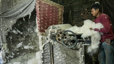 A worker feeds raw cotton into an opener machine at a processing facility in Amritsar (AFP) A worker feeds raw cotton into an opener machine at a processing facility in Amritsar (AFP)