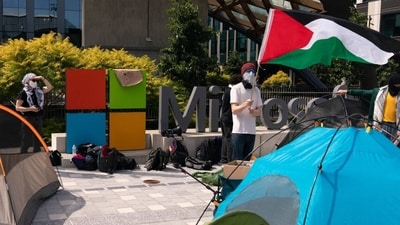 A demonstrator holding a Palestinian flag near tents during a protest at Microsoft’s campus in Redmond, Wash., this month. A demonstrator holding a Palestinian flag near tents during a protest at Microsoft’s campus in Redmond, Wash., this month.