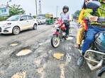 Commuters move amid the broken patches of the flyover after the Friday rain. (RAJ K RAJ /HT PHOTO)
