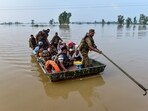 Indian Army personnel rescue local residents using a boat to evacuate through the flooded waters of the Beas River in Kapurthala. Indian Army personnel rescue local residents using a boat to evacuate through the flooded waters of the Beas River in Kapurthala.