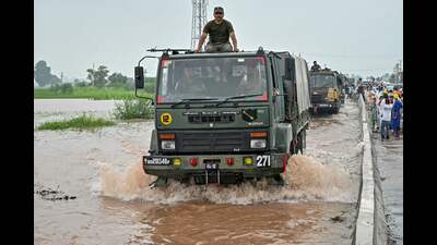 Indian Army personnel on their trucks arrive to rescue flood victims stranded in floodwaters after a rise in water level of the Ravi river at a village near Ajnala, Amritsar on Friday. (AFP)