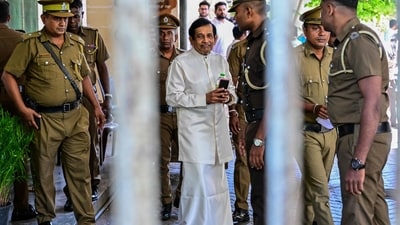 Security officers escort Sri Lankan former fisheries minister, Rajitha Senaratne (C), outside a court in Colombo on Friday. (AFP)
