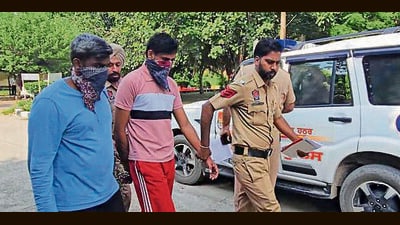 The accused (centre) in police custody on Friday. (HT Photo)