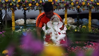 A devoted volunteer immerses a Ganapati idol in an artificial pond in Mumbai, amidst floating rose petals and draped marigold garlands, painting a magnificent picture of devotion and celebration. (REUTERS)