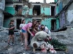 Girls wipe dust off of a teddy bear in front of a house that was destroyed by a Russian strike Ukraine. Girls wipe dust off of a teddy bear in front of a house that was destroyed by a Russian strike Ukraine.