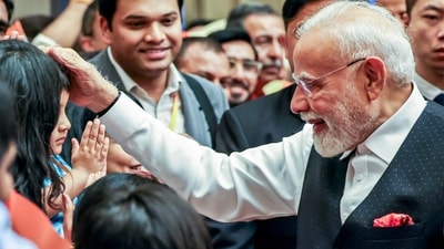 Prime Minister Narendra Modi embraces a child during a rousing welcome from the Indian community upon his arrival at a hotel, in Tianjin on Saturday. (ANI) Prime Minister Narendra Modi embraces a child during a rousing welcome from the Indian community upon his arrival at a hotel, in Tianjin on Saturday. (ANI)