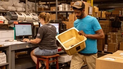 Jarvis Walker, who has been working at Thompson Traders for four years, carries a sink to be packaged and shipped. Jarvis Walker, who has been working at Thompson Traders for four years, carries a sink to be packaged and shipped.