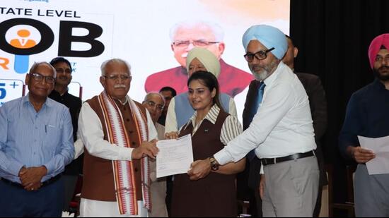 Union power minister Manohar Lal Khattar giving out job letters to applicants during a placement campaign in Karnal on Saturday. (HT Photo)
