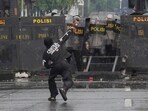 Police officers cover themselves with riot shields as a protester throws rock at them during a protest against lavish allowances given to parliament members, outside the parliament in Jakarta, Indonesia, Sunday, Aug. 31, 2025. Police officers cover themselves with riot shields as a protester throws rock at them during a protest against lavish allowances given to parliament members, outside the parliament in Jakarta, Indonesia, Sunday, Aug. 31, 2025.