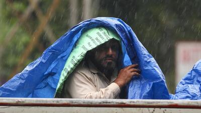 A man covers himself with a plastic sheet amid rainfall, in Jammu, on Sunday. (PTI) A man covers himself with a plastic sheet amid rainfall, in Jammu, on Sunday. (PTI)