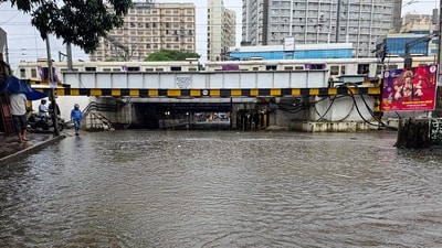 A train passes above a waterlogged underpass during heavy rainfall, at Andheri, in Mumbai (PTI) A train passes above a waterlogged underpass during heavy rainfall, at Andheri, in Mumbai (PTI)