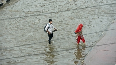 People wading through a waterlogged road in UP's Ghaziabad on Friday (Sakib Ali /Hindustan Times)