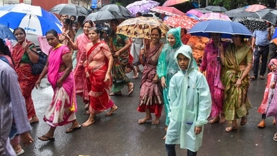 People protect themselves with umbrellas amid rainfall in Surat on Sunday (PTI) People protect themselves with umbrellas amid rainfall in Surat on Sunday (PTI)