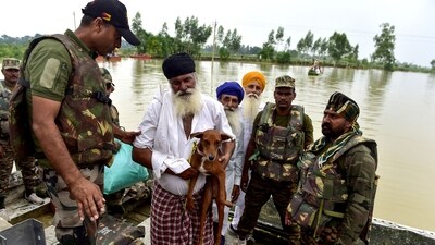 Indian army personnel rescue flood-affected residents and their dog on a boat across the Beas river at Baoopur village in Kapurthala (AFP) Indian army personnel rescue flood-affected residents and their dog on a boat across the Beas river at Baoopur village in Kapurthala (AFP)