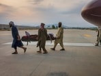 People carry an earthquake victim on a stretcher to an ambulance at an airport in Jalalabad, Afghanistan, 