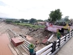 A portion of a temple collapses on the banks of the Tawi River following heavy rains, in Jammu.
