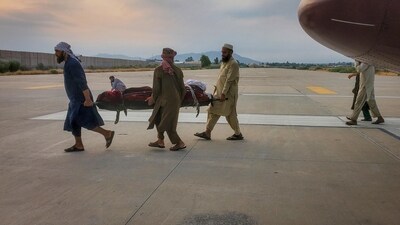 People carry an earthquake victim on a stretcher to an ambulance at an airport in Jalalabad, Afghanistan, (REUTERS)
