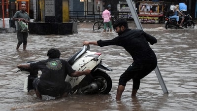 Two men try to pull out the scooter after it gets stuck on a waterlogged road amid rain in Delhi. (ANI) Two men try to pull out the scooter after it gets stuck on a waterlogged road amid rain in Delhi. (ANI)
