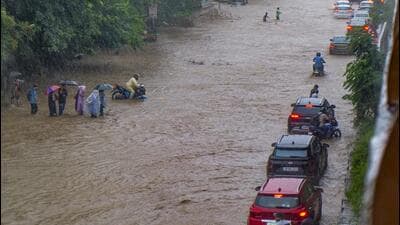 Commuters on a waterlogged road in Gurugram on Monday. (PTI) Commuters on a waterlogged road in Gurugram on Monday. (PTI)