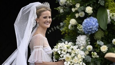 Princess Marie Caroline looked radiant in a classic white gown with sheer lace details and short sleeves, paired with heirloom royal jewelry and a sweeping veil, as reported by PEOPLE. (Walter Bieri/Keystone via AP) (AP)
