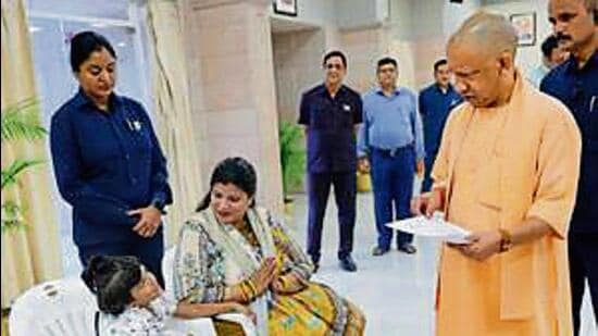 Chief minister Yogi Adityanath meets Mayra and her mother at Janata Darshan in Lucknow on Monday. (HT)