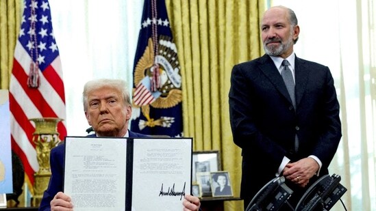 President Donald Trump holds an executive order about tariffs increase, flanked by Commerce Secretary Howard Lutnick, in the Oval Office in Feburary.