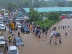 Commuters making their way through a waterlogged road in Gurugram. (PTI) Commuters making their way through a waterlogged road in Gurugram. (PTI)