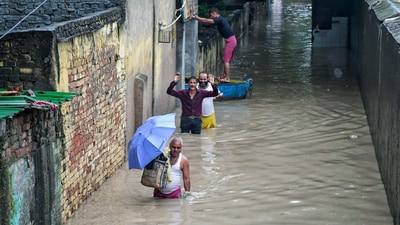People walk through a waterlogged area in Delhi's Yamuna Bazar as Yamuna's water level crosses danger mark following incessant rainfall on Tuesday. (ANI) People walk through a waterlogged area in Delhi's Yamuna Bazar as Yamuna's water level crosses danger mark following incessant rainfall on Tuesday. (ANI)