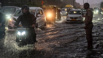 Security personnel kept their vigil as commuters made their way through the waterlogged Delhi-Gurugram expressway amid rainfall, in Gurugram on Monday. (PTI) Security personnel kept their vigil as commuters made their way through the waterlogged Delhi-Gurugram expressway amid rainfall, in Gurugram on Monday. (PTI)