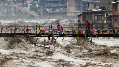 Residents run across a bridge over the flooding Beas River following incessant rains in Kullu, Himachal Pradesh. (AP) Residents run across a bridge over the flooding Beas River following incessant rains in Kullu, Himachal Pradesh. (AP)