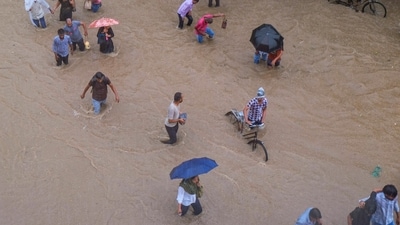 Commuters make their way through a waterlogged road amid rainfall in Gurugram on Monday (PTI)