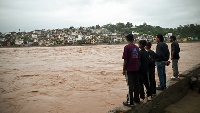 People look on as the river Tawi flows above the danger level following flash floods triggered by heavy rainfall, at Gorkha Nagar in Jammu on Tuesday. (ANI) People look on as the river Tawi flows above the danger level following flash floods triggered by heavy rainfall, at Gorkha Nagar in Jammu on Tuesday. (ANI)