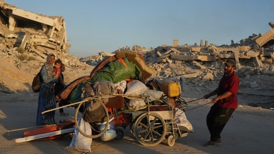 Displaced Palestinians fleeing northern Gaza Strip move with their belongings along the Sea Road, in Gaza City, Monday, Sept. 1, 2025. (AP Photo/Jehad Alshrafi) (AP)