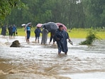 People wade through a flooded road in Tailbal area of Srinagar on Wednesday. (Waseem Andrabi /HT)