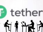 Figurines with computers and smartphones are seen in front of Tether logo in this illustration taken