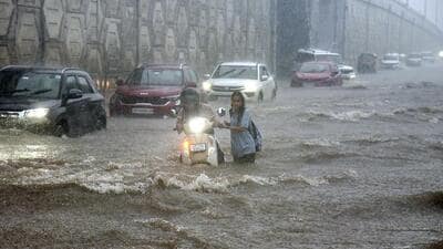 People crossing the rain water filled national highway near wave city in Ghaziabad on Tuesday. (Sakib Ali /Hindustan Times) People crossing the rain water filled national highway near wave city in Ghaziabad on Tuesday. (Sakib Ali /Hindustan Times)