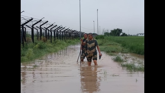 Border Security Force jawans patrolling along the waterlogged fencing in Ferozepur on Wednesday. (HT)