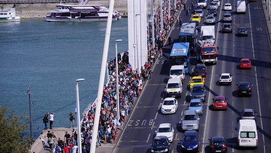 (FILES) Hundreds of migrants walk on the Elisabet Bridge after leaving the transit zone of the Budapest main train station, on September 4, 2015 intenting on walking to the Austrian border. "We can do this," Angela Merkel famously declared on August 31, 2015 as columns of desperate people walked through the Balkans towards Germany (AFP FILE)