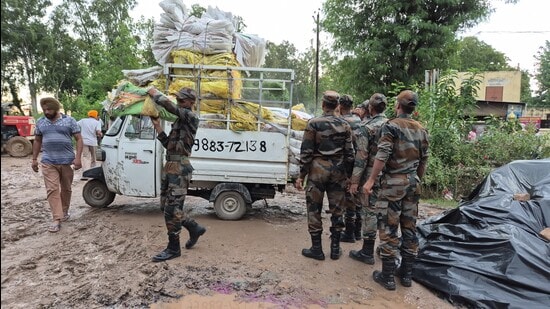 Security personnel make safety arrangements for people amid rising water level of the Ghaggar river, in Patiala, Wednesday. (HT Photo)