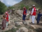 Red Crescent volunteers walk next to damaged houses as they reach Lulam village to help the victims following a deadly magnitude-6 earthquake that struck Afghanistan on Sunday, in Nurgal district, Kunar province, Afghanistan, September 3, 2025. 