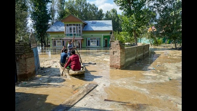 Men row their boat through a flood-affected area in Budgam district on Thursday. (PTI) Men row their boat through a flood-affected area in Budgam district on Thursday. (PTI)