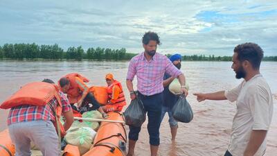Rupinder Pal Singh (in pink) has been busy evacuating people from low-lying and flood affected areas, taking them to relief camps for shelter during the Punjab floods. (HT)