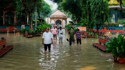 People at New Delhi's Nigambodh Ghat were seen wading through knee-deep water after water from the Yamuna river entered the area on Thursday. (PTI) People at New Delhi's Nigambodh Ghat were seen wading through knee-deep water after water from the Yamuna river entered the area on Thursday. (PTI)