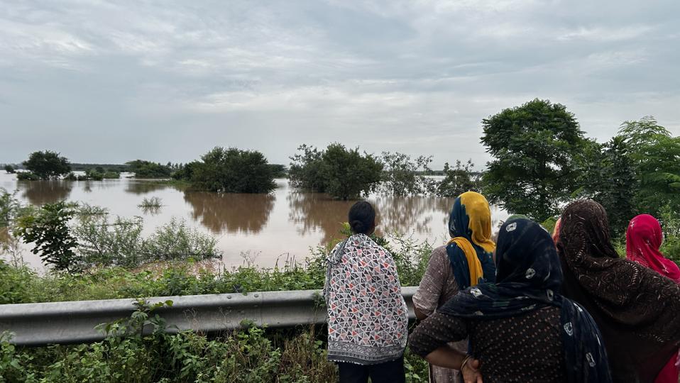 Villagers watching inundated surroundings after the Ghaggar breached the Bhakra Canal in Ghanaur block of Patiala district on Thursday. (HT Photo) Villagers watching inundated surroundings after the Ghaggar breached the Bhakra Canal in Ghanaur block of Patiala district on Thursday. (HT Photo)
