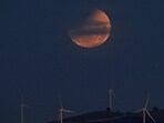 The blood moon happens when Earth’s shadow fully covers the moon, making it look deep red or orange. (Photo by Izhar KHAN / AFP)