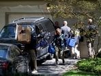 FBI agents carry boxes outside the home of the former White House national security adviser John Bolton as it is searched in August this year 