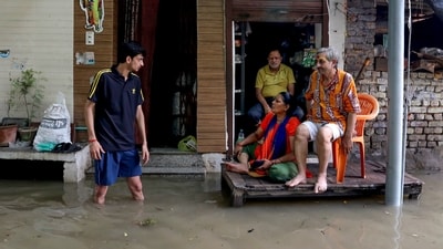 Residents outside a partially submerged house as the Yamuna river continues to inundate low-lying areas at the Yamuna Bazar in New Delhi. (PTI) Residents outside a partially submerged house as the Yamuna river continues to inundate low-lying areas at the Yamuna Bazar in New Delhi. (PTI)